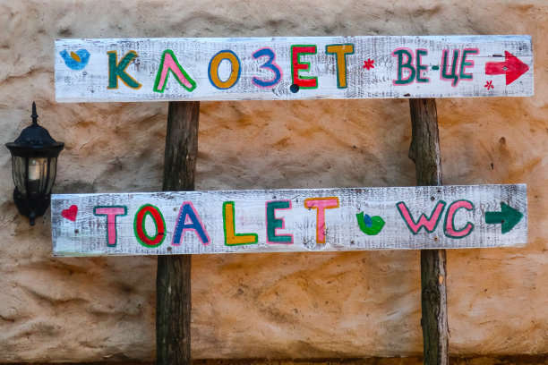 在塞尔维亚Drvengrad的Ethno村，石墙上的木制公共厕所标志图片下载
