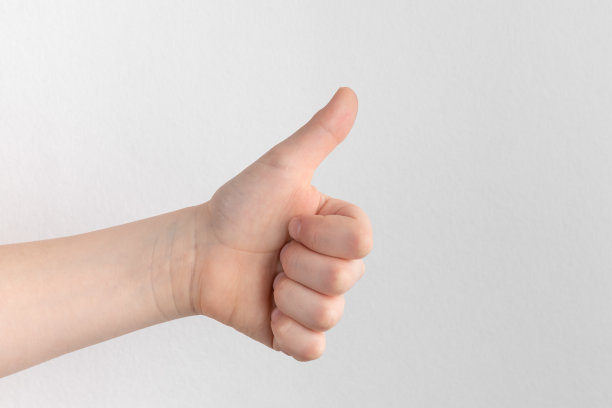 儿童的手或儿童的手显示拇指孤立在白色和灰色的背景图片下载