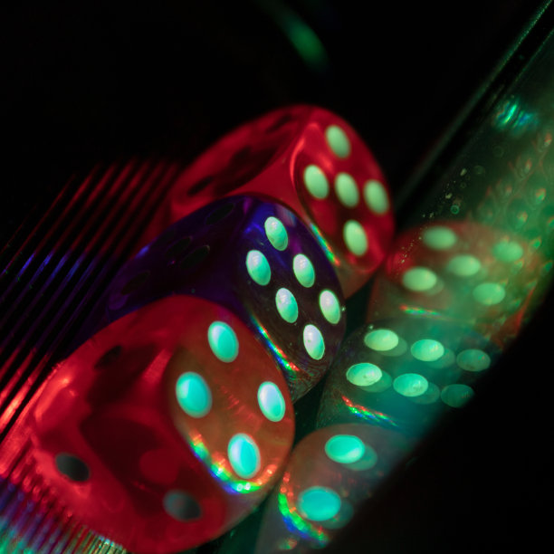 三个骰子旁边的倒影被彩色的光覆盖图片下载