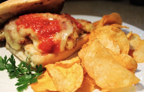 免版税照片-餐厅网站、美食博客或广告应用的最佳食物背景-美食家手面包鸡帕尔马三明治烤蒜夏巴塔卷的迷人特写-最受欢迎的午餐三明治特别图片下载