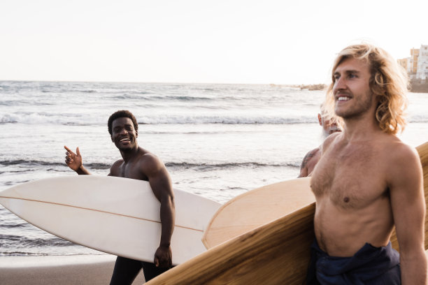 快乐的多种族冲浪者朋友持有冲浪板后，极限水上运动训练在海滩-关注非洲人的脸图片下载