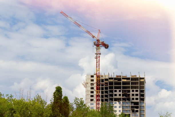 建筑起重机在明亮的阳光下。正在施工的房子和起重机。图片下载