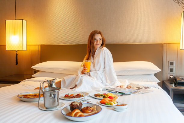 床上的食物供应在豪华酒店，度假的女人享受早餐图片下载