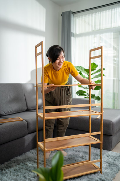 亚洲妇女正在家中客厅里组装家具。图片下载