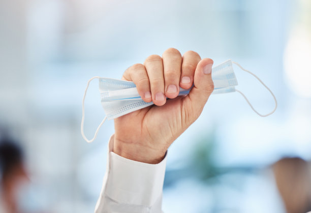 新冠肺炎，在大流行卫生法规改变社会距离的情况下，手握拳头和戴口罩。新常态、疫苗健康与放松公共场所病毒防护密切相关。图片下载