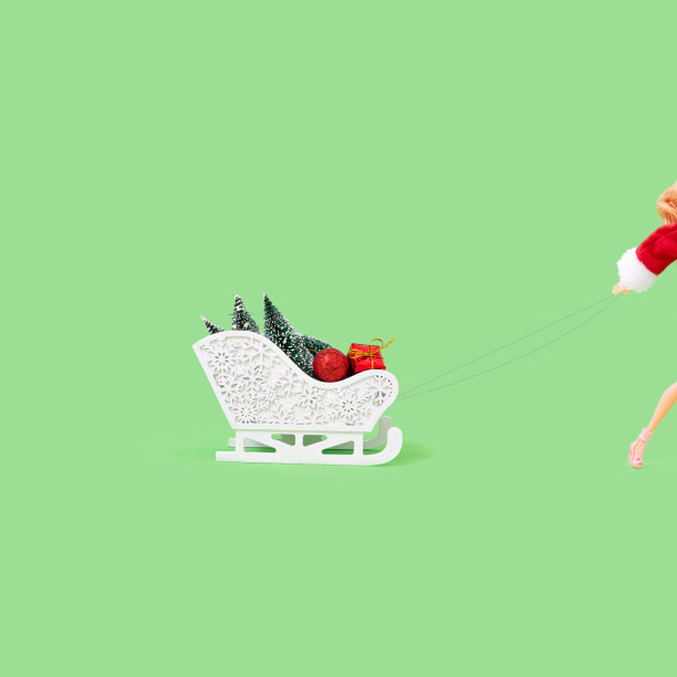 迷人性感的女性身体在圣诞老人套装与白色的雪橇装满了礼物和小圣诞树。新年横幅概念艺术作品。图片下载