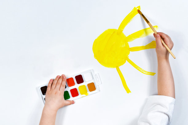 孩子们的手正在画阳光水彩画。孩子的创造力，绘画能力，早期发展。铭文的地方。图片下载