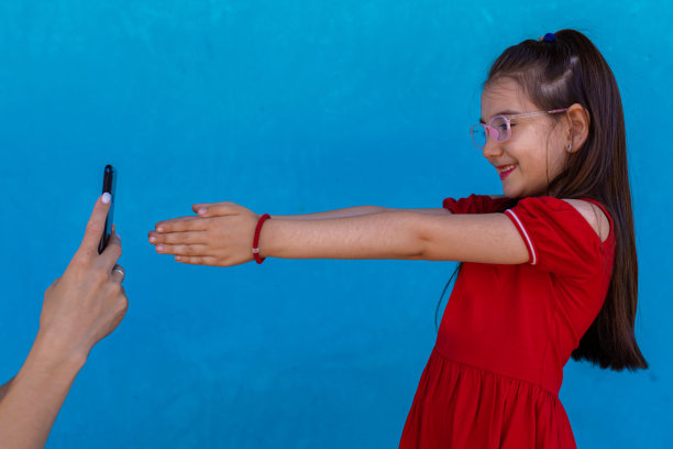 母亲和蹒跚学步的女儿正在用智能手机拍照图片下载