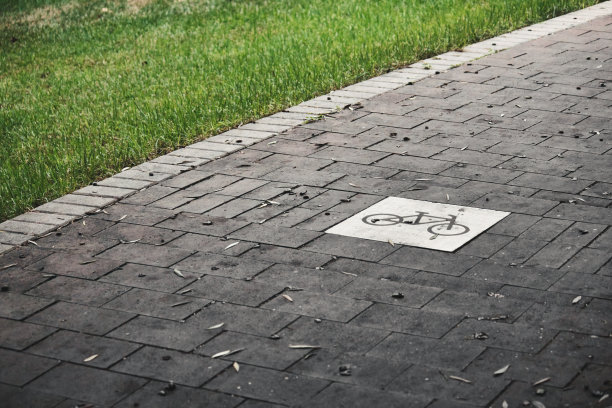 公园里草地之间的一条空自行车道图片下载