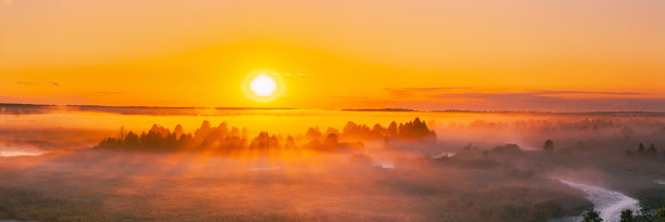 在朦胧的风景上令人惊叹的日出。雾蒙蒙的森林上方日出的雾蒙蒙的早晨天空的风景。欧洲的仲夏自然。全景,全景拍摄图片下载