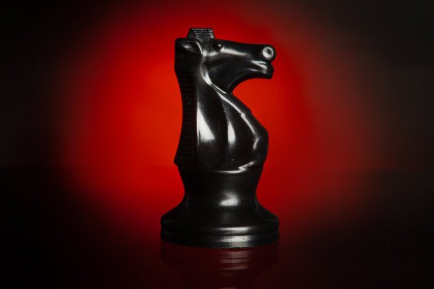 国际象棋棋子在深色背景与红色背光接近图片下载