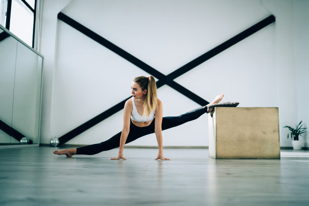 冷静的赤脚运动员在健身房训练时伸展双腿图片下载