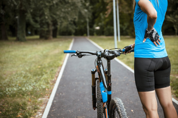 背部疼痛的女自行车手图片下载