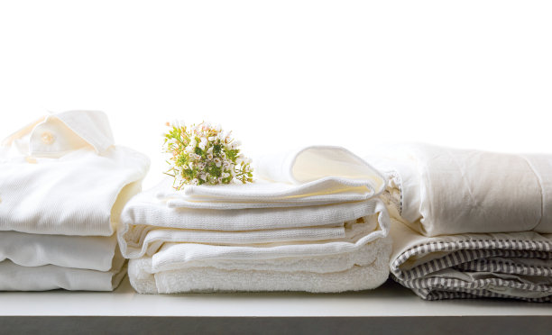 白色干净的床和衣服放在桌子上孤立的背景图片下载