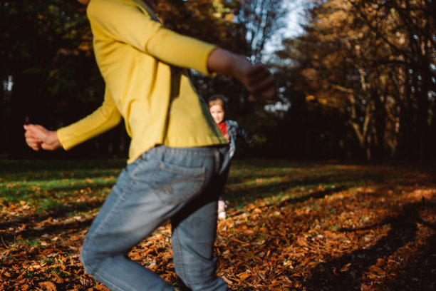 一个女孩在秋天的公园里玩耍的模糊动作图片下载