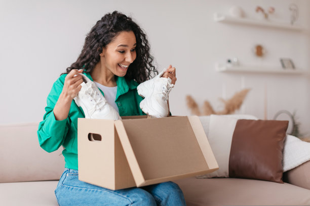 快乐的顾客女士在家里拿着鞋子开箱图片下载