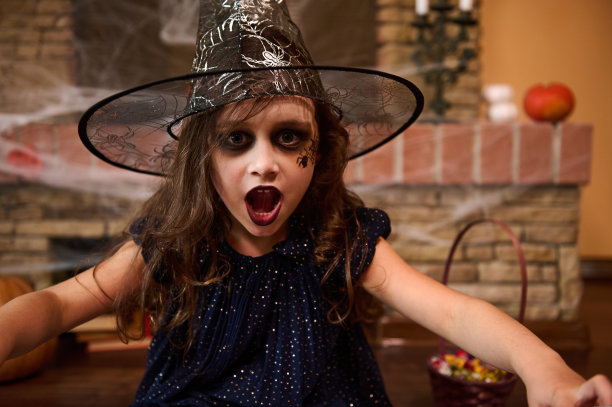 哥特风格的小女孩，脸上画着一只蜘蛛，戴着巫师帽，对着镜头施咒图片下载