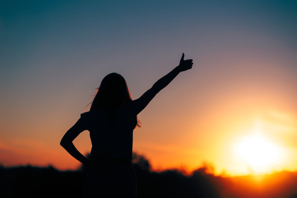 背光剪影的一个女人的大拇指图片下载