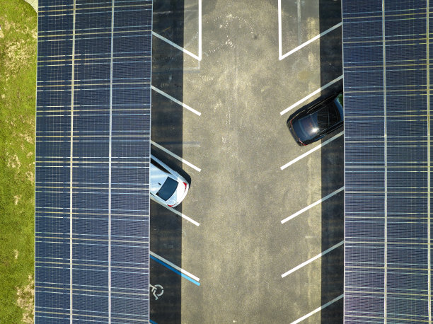 太阳能电池板安装在停车场停放的汽车，有效地产生清洁能源图片下载