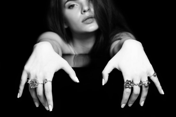 工作室的美丽和性感的女人与花哨的化妆和各种戒指在她的手指肖像图片下载