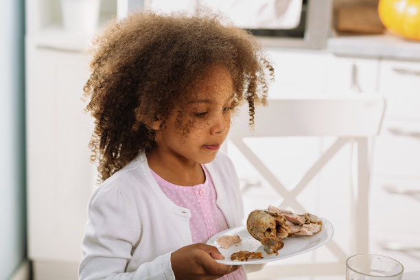 一个非裔美国女孩准备在感恩节咬下一只填充火鸡图片下载