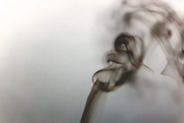 在黑色背景下点燃的香烟。图片下载