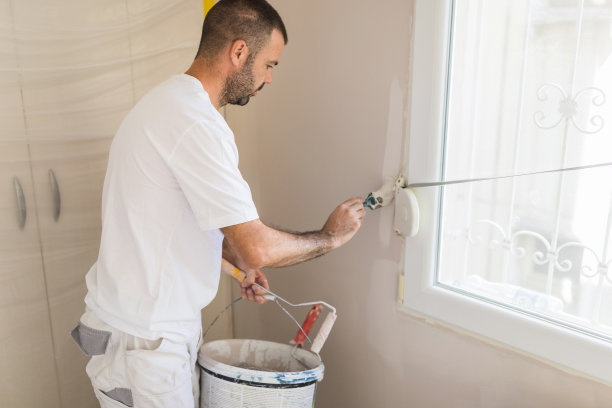 有人在窗户的角落刷墙图片下载