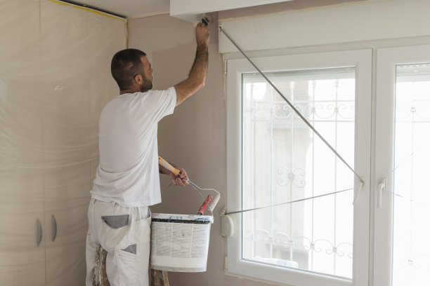 男人拿着一桶油漆刷天花板图片下载