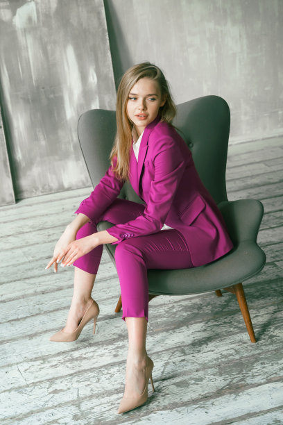 年轻的女商人。美丽的女人董事，主管，总经理，ceo在时尚明亮的商业粉色，紫红色的颜色西装在扶手椅上拍照。事业有目的有野心的女孩野心家图片下载