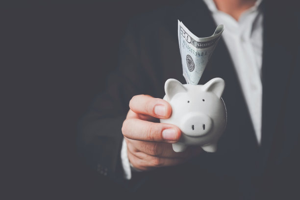 节能省钱的理念。储蓄或投资的想法。手把钱硬币放进小猪存钱财富存钱硬币在表概念金融。图片下载