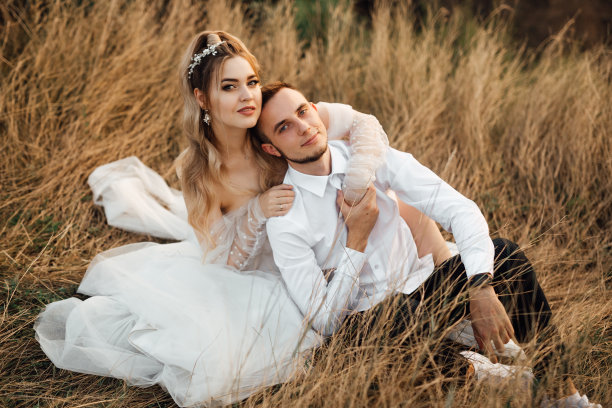 一对欢快的情侣相恋，新娘和新郎欢声笑语地迎着夕阳图片下载