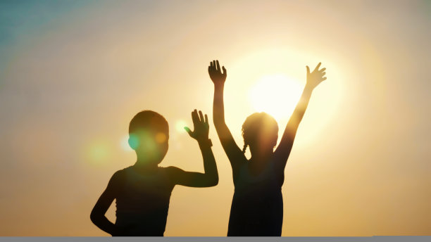 剪影，孩子们的身影，男孩和女孩跳跃，玩耍，跳舞，拥抱在太阳的背景下，在夏天的日落。幸福的家庭。慢动作图片下载