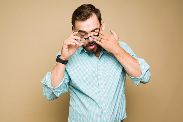 视力有问题，戴眼镜的疲惫男子图片下载