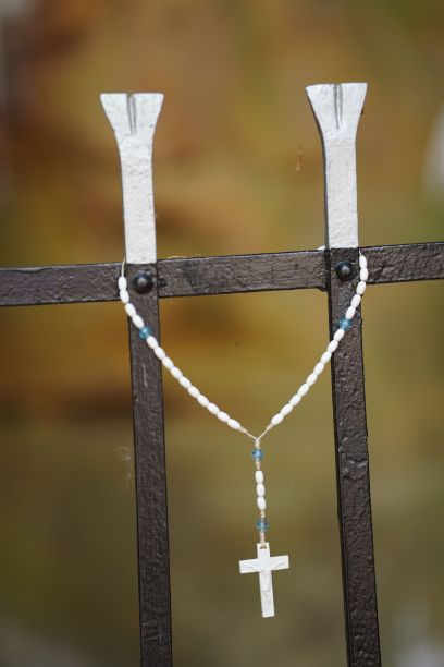 项链与十字架挂在金属栅栏图片下载