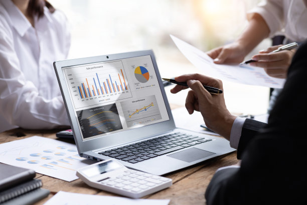 市场财务分析师在公司会议上讨论时分析了关于数字平板电脑的商业财务报告，展示了他们成功的团队合作成果。、商务会议概念、图片下载