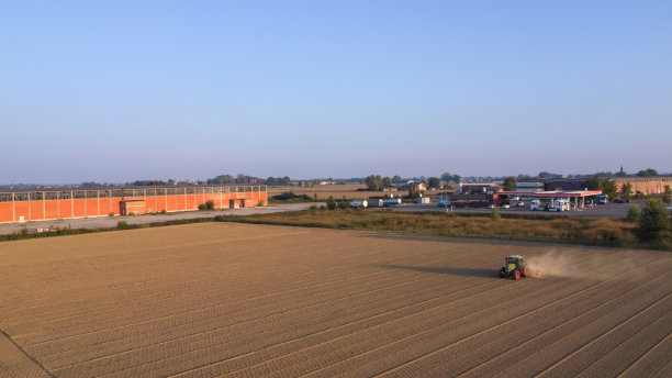 农用拖拉机将土地挤压到密实土壤平整的鸟瞰图图片下载
