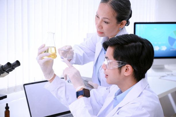 聪明的年轻亚洲男科学家和他的女前辈在实验室里一起工作和头脑风暴。图片下载