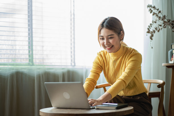 亚洲女性在咖啡店使用笔记本电脑在网上购物图片下载