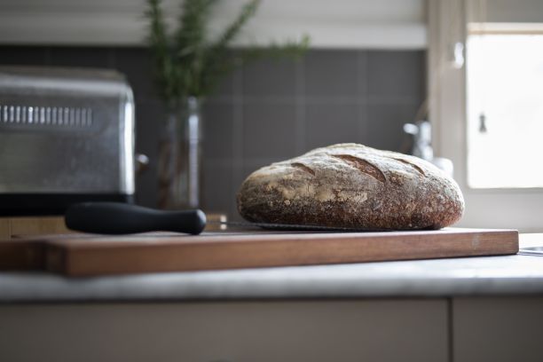 在厨房的木板上放着一把刀的面包图片下载