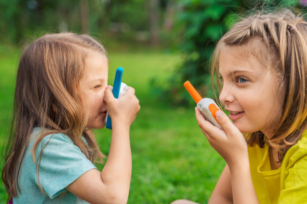 小孩，女孩玩对讲机。带频道的对讲机。侦探，间谍的游戏。孩子们在远处说话，说信息。在森林、公园、远足与家长交流。找到失踪的人图片下载