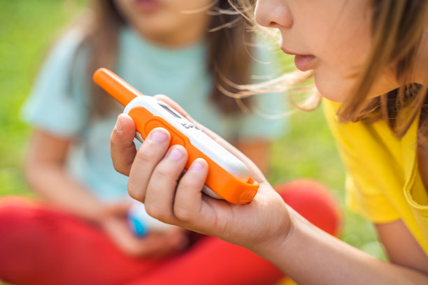 小孩，女孩玩对讲机。带频道的对讲机。侦探，间谍的游戏。孩子们在远处说话，说信息。在森林、公园、远足与家长交流。找到失踪的人图片下载