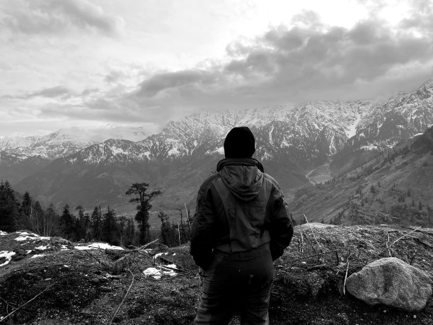 一个徒步旅行者在印度马纳利的山顶上欣赏风景的灰度照片图片下载
