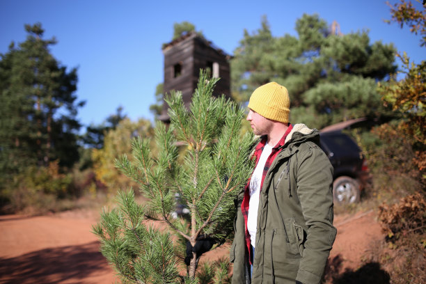 这位帅哥为他的家庭照片选择了一棵完美的圣诞树图片下载