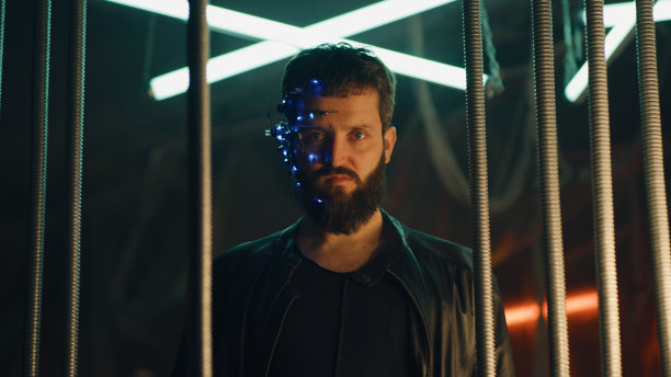 年轻人戴着头戴式LED灯站在黑色吊杆后面图片下载