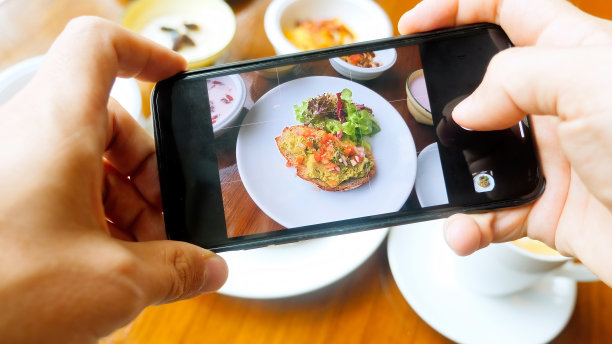 一名男子在咖啡馆的木桌上用手拍摄健康早餐图片下载