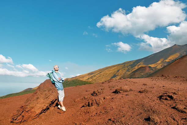 快乐的女游客享受着自由，欣赏着欧洲大陆最高的火山，意大利西西里岛的埃特纳活火山五彩缤纷的山峰全景。图片下载