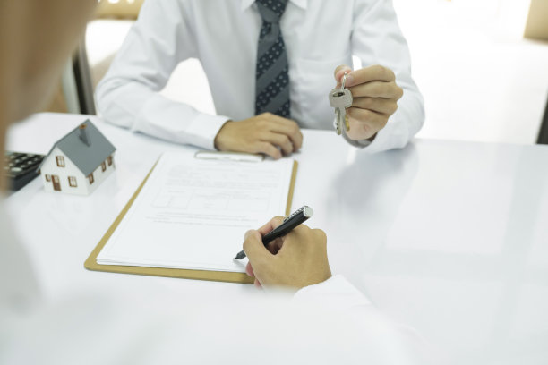 房地产经纪人在签订房屋贷款合同后将房屋钥匙交给客户。图片下载