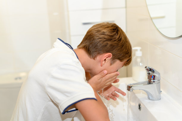 青春期前的孩子在马桶水槽里洗脸图片下载