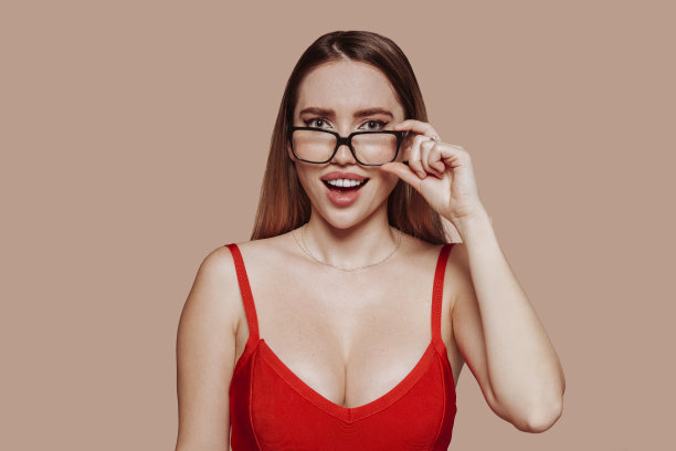 性感年轻惊讶的女人穿着红色的裙子和眼镜图片下载