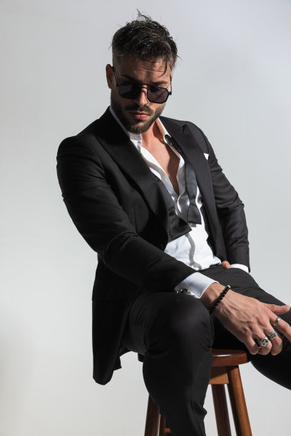 有胡子的迷人男子坐在木椅上的照片图片下载